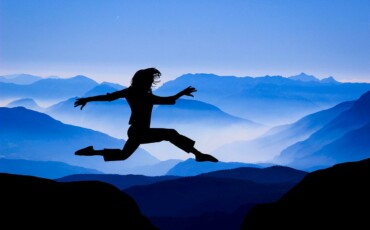 Femme qui saute entre deux montagnes