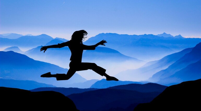 Femme qui saute entre deux montagnes
